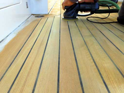 Marine engineer sanding a deck